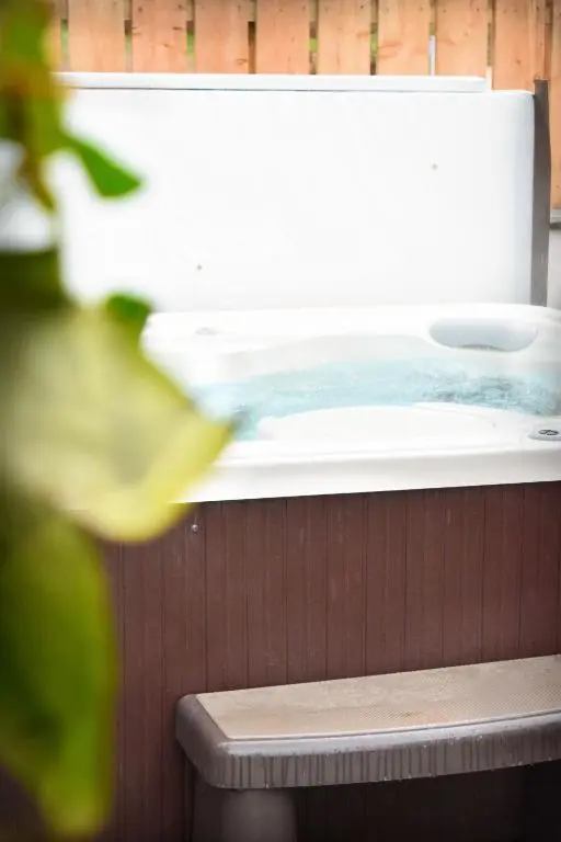 a bath tub filled with water next to a wooden wall at The Auld Reekie in Barbaraville