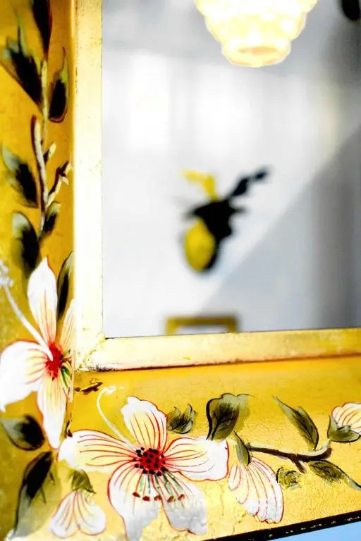 a mirror with flowers and a bird on a wall at The Auld Reekie in Barbaraville