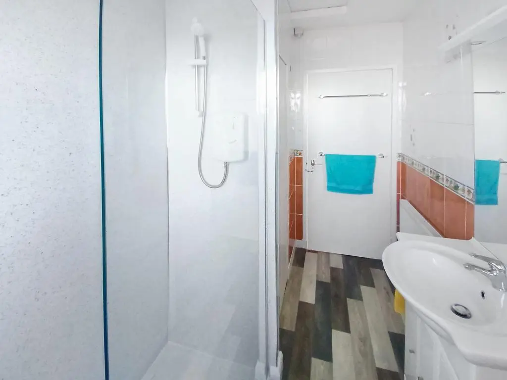 a bathroom with a shower and a sink and a toilet at Sea Breeze Cottage in Buckie