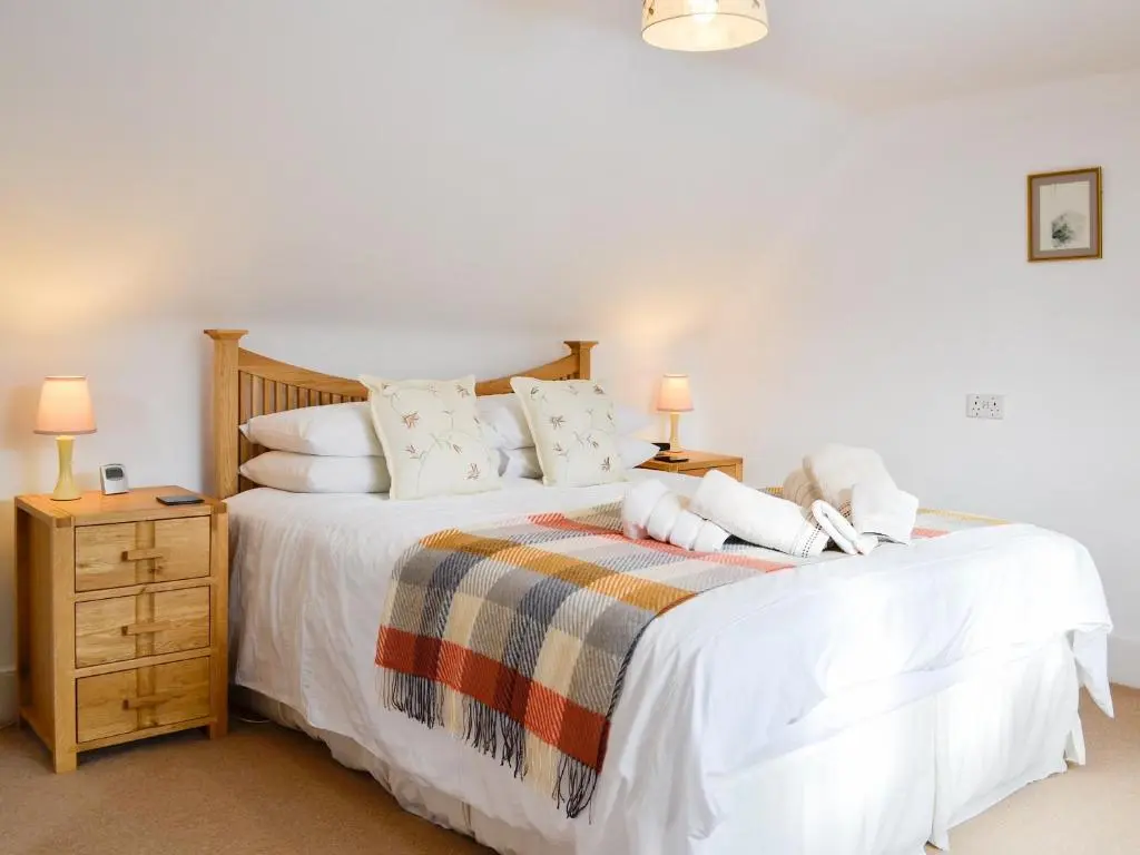 a bedroom with a bed with white sheets and pillows at Craigclunie in Ballater