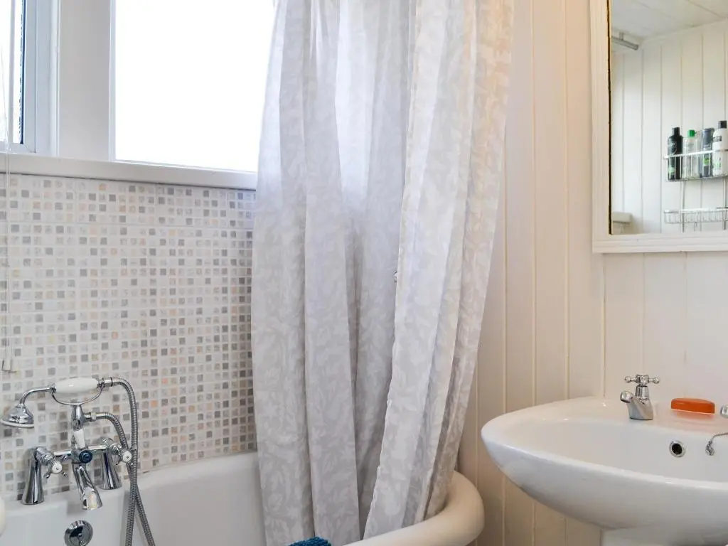 a bathroom with a shower curtain and a sink at Craigclunie in Ballater