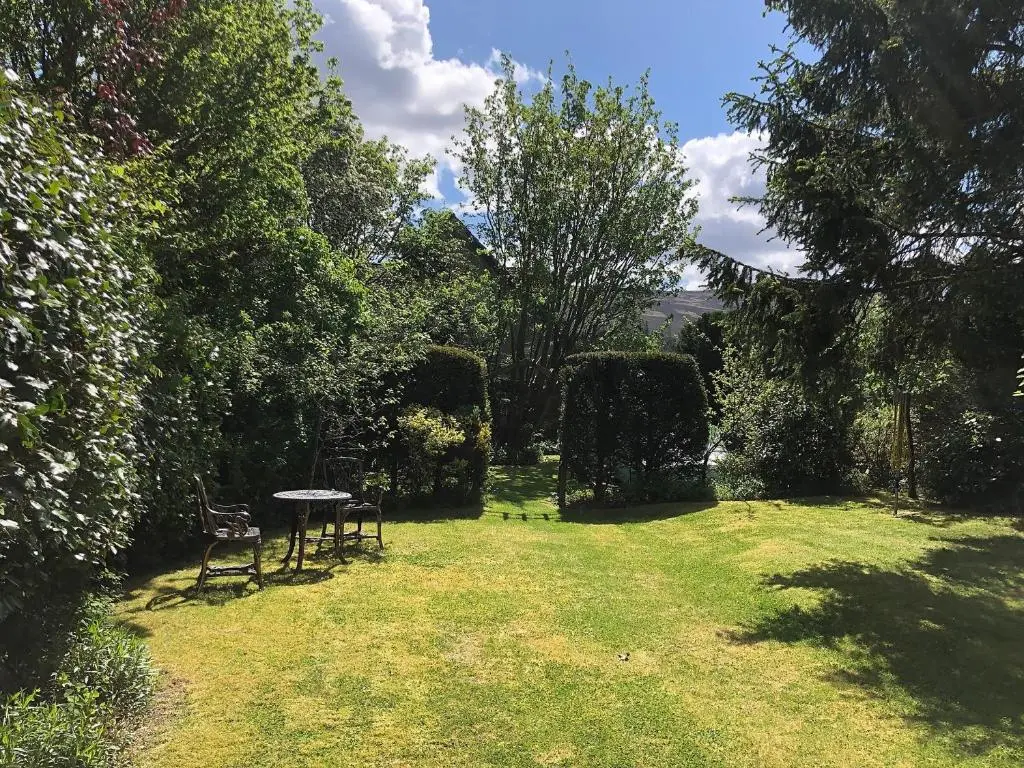 a garden with a table and chairs in the grass at Craigclunie in Ballater