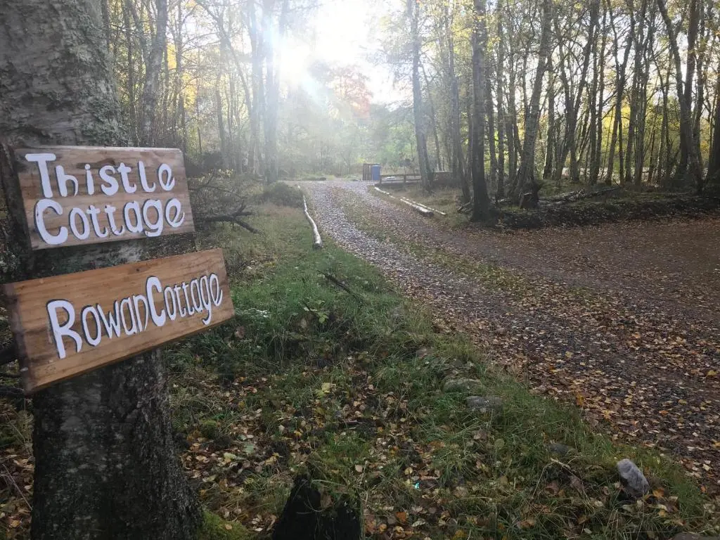 a sign on a trail in the woods at Thistle Cottage, CrannachCottages in Garve