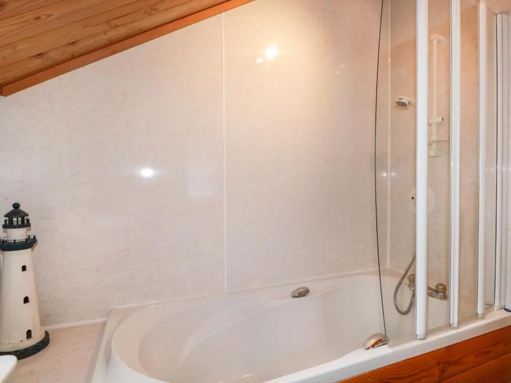 a white bath tub with a glass shower door at Torbreck Chalet in Kingussie