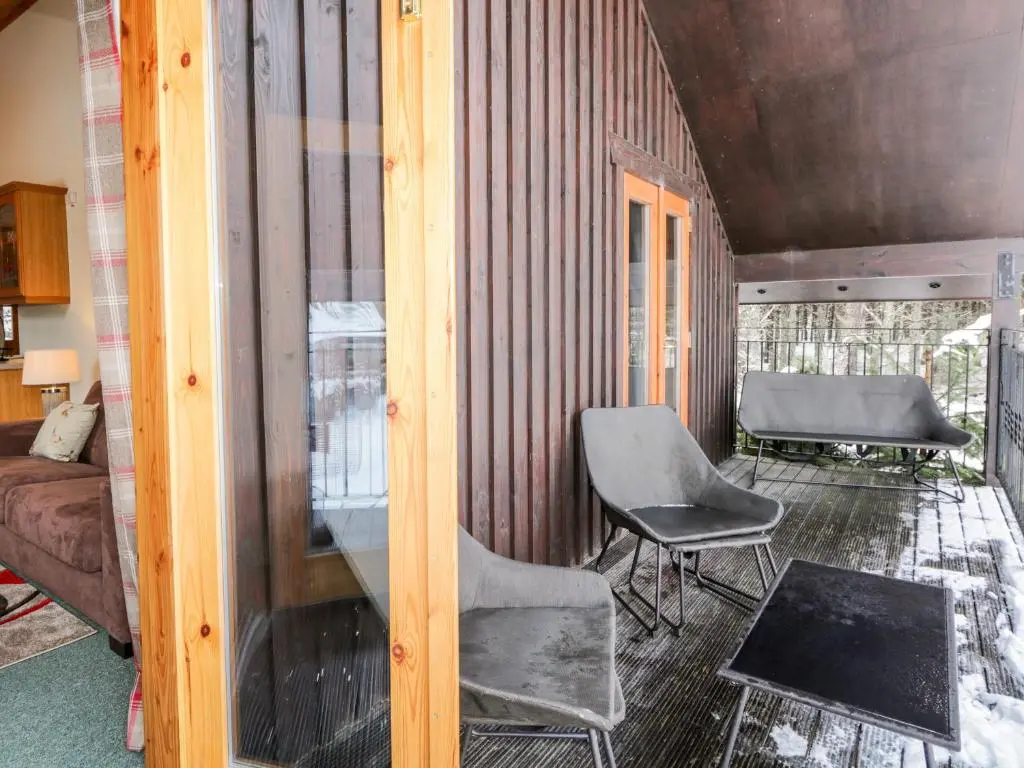 a room with two chairs and a bed at Torbreck Chalet in Kingussie