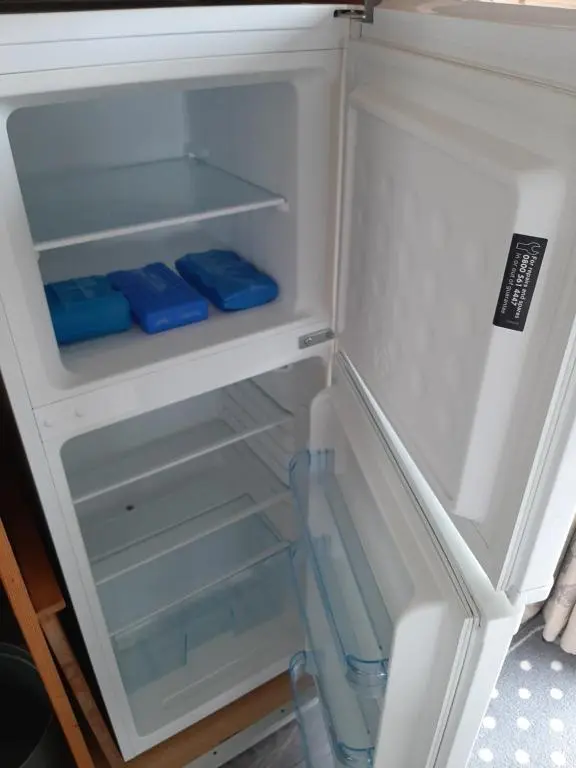 an open refrigerator with blue items in it at Taid's Retreat Silversands Cove beach lossiemouth in Lossiemouth