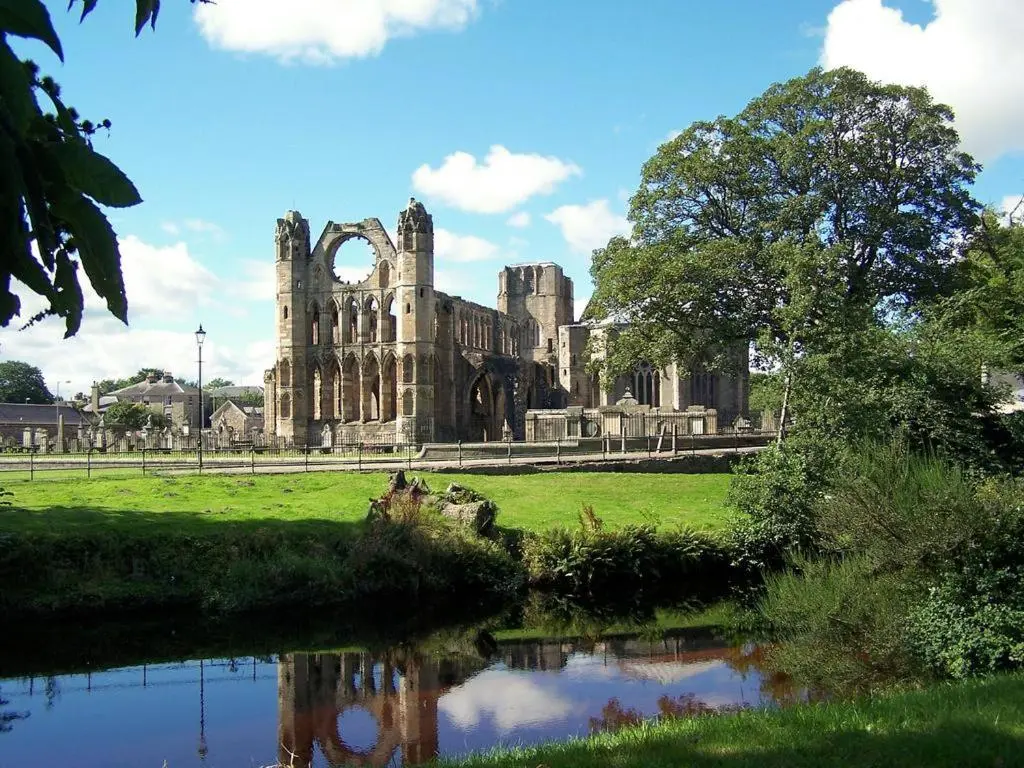 an old castle with a pond in front of it at River View Apartment in Elgin
