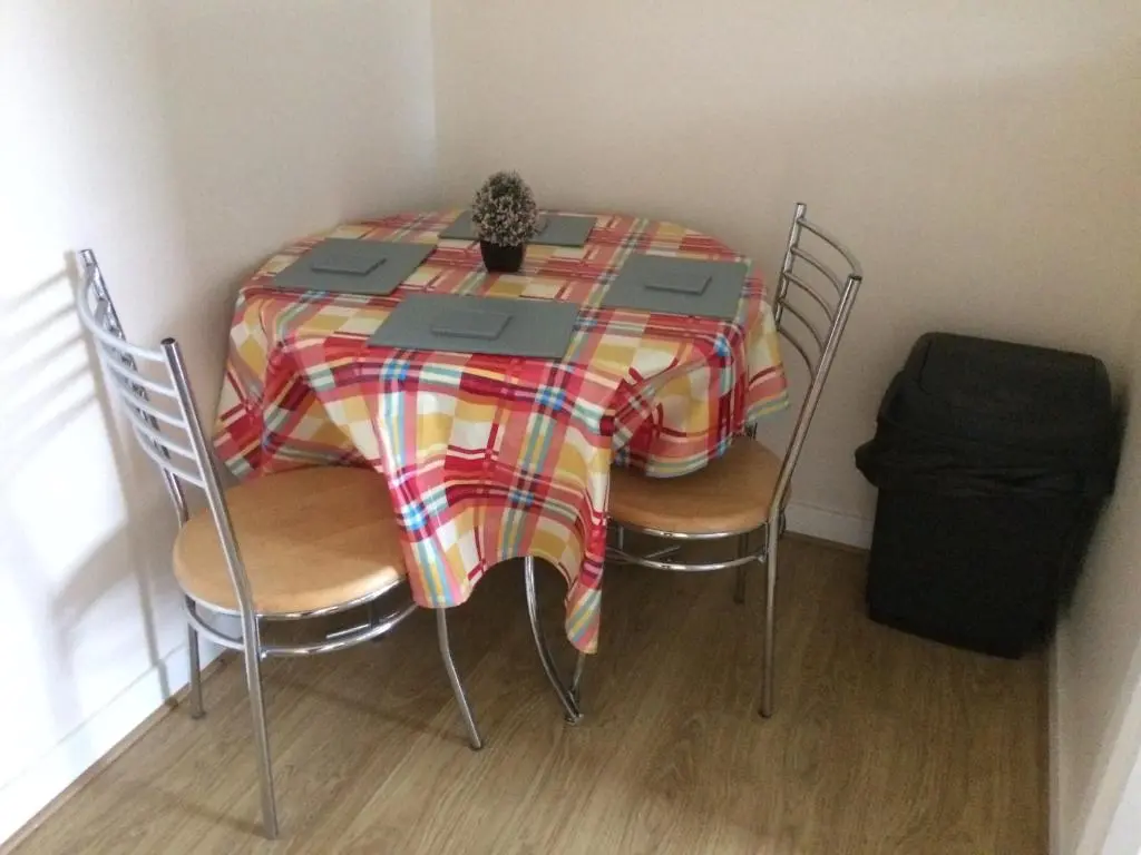 a dining room table with a plaid table cloth on it at River View Apartment in Elgin