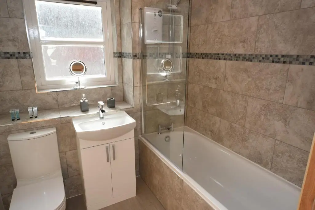 a bathroom with a toilet and a sink and a bath tub at Silver Key Apartment 2 in Inverness
