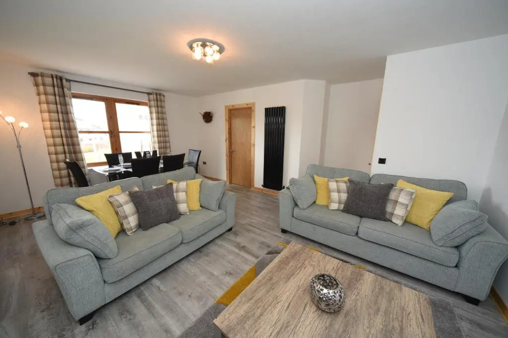 a living room with two couches and a table at Silver Key Apartment 2 in Inverness