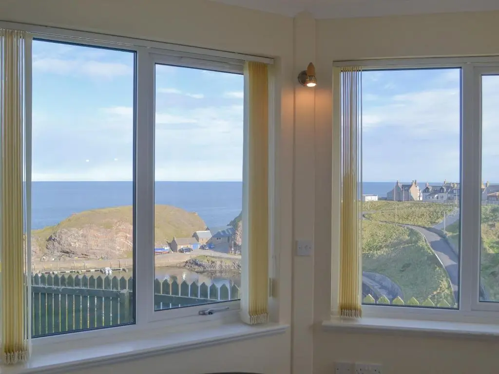 a room with three windows looking out at the ocean at White Gables - Uk30688 in Portknockie