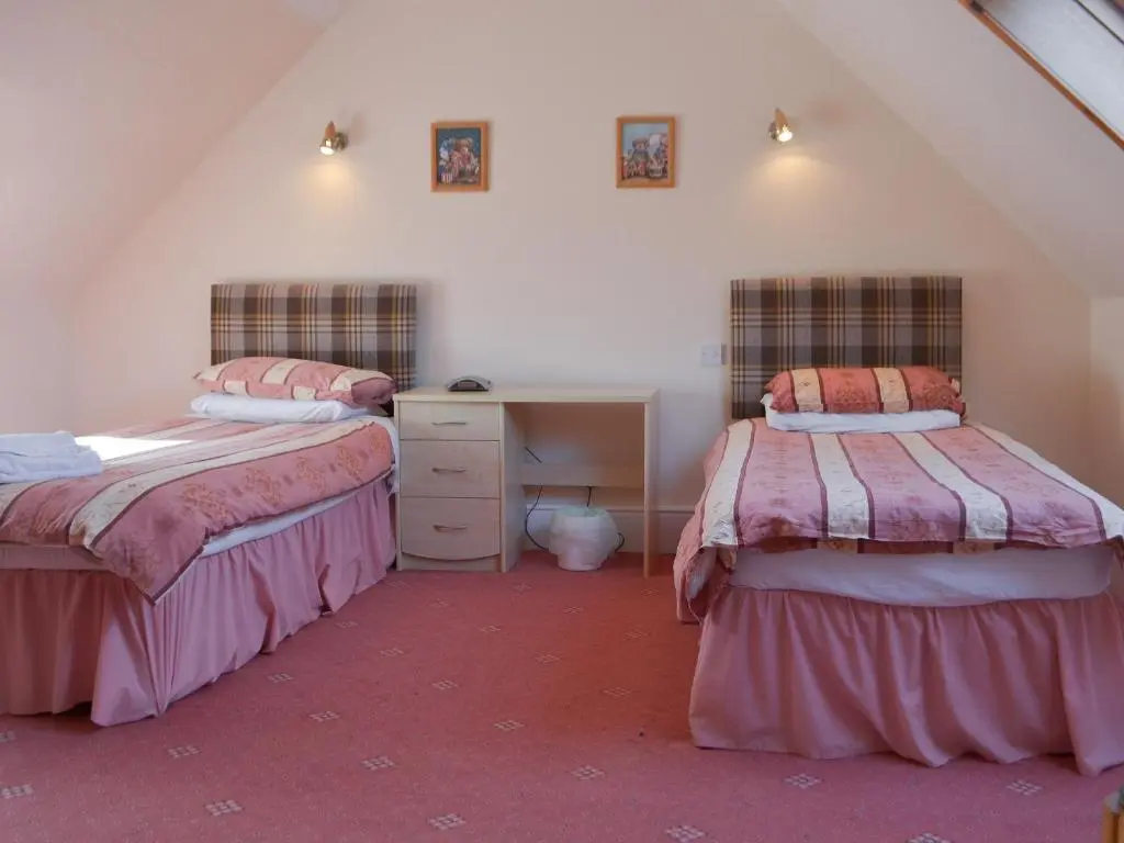a bedroom with two beds and a desk in a attic at Dolphin View - Uk30689 in Portknockie