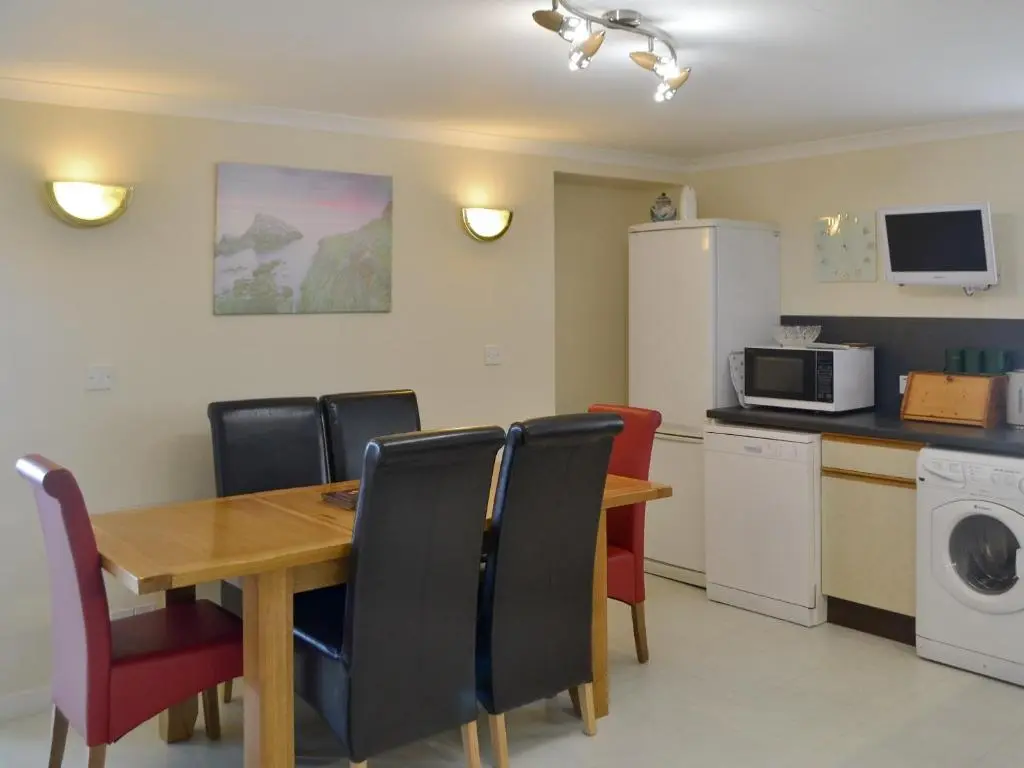 a kitchen with a table and chairs and a microwave at Seabreezes - Uk30690 in Portknockie