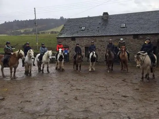 a group of people riding horses on a dirt road at Highland HotTub Retreat, on NC500 in Inverness