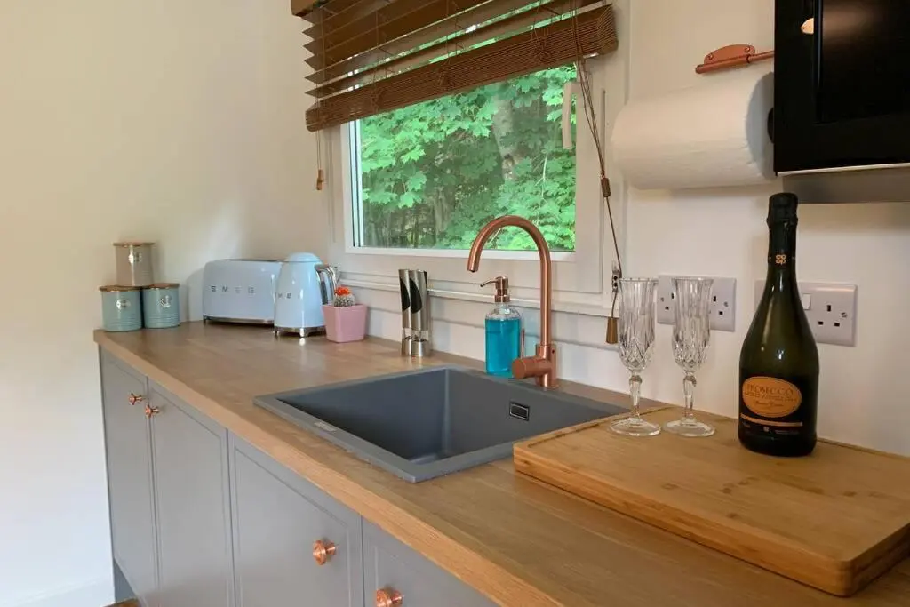 a kitchen with a sink and a bottle of wine at Highland HotTub Retreat, on NC500 in Inverness