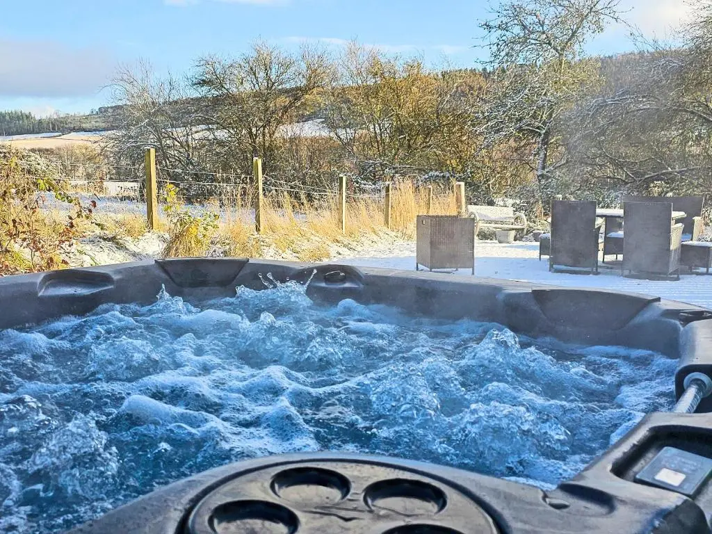 a tub full of water with snow in it at Balmore Farmhouse in Lochend