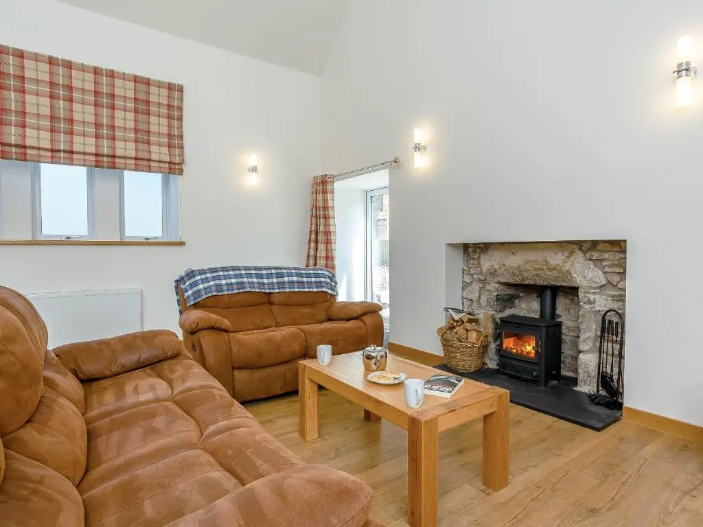 a living room with two couches and a fireplace at Auld Kirk Hall in Kirktown of Auchterless