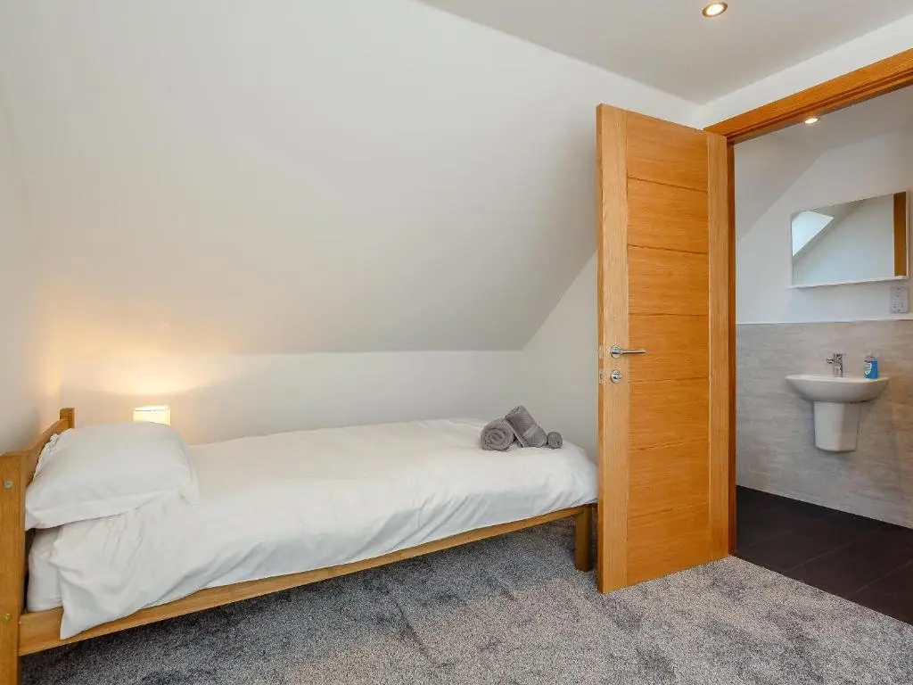 a small bedroom with a bed and a sink at Auld Kirk Hall in Kirktown of Auchterless