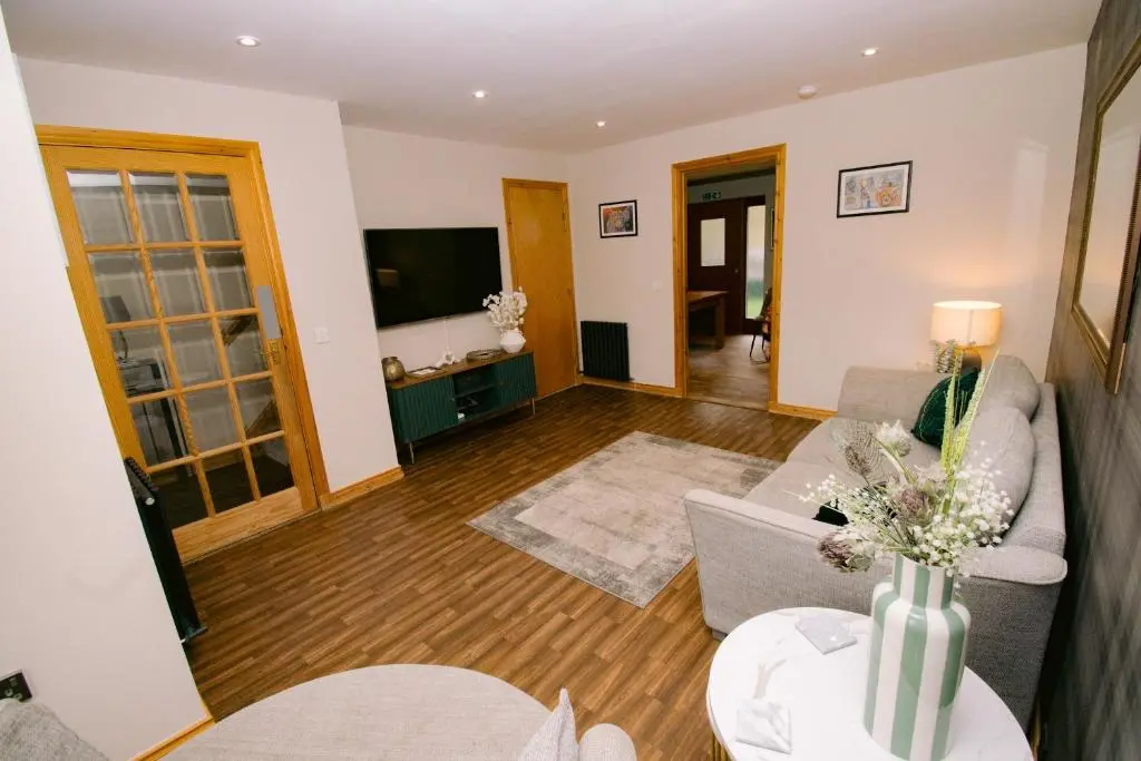 a living room with a couch and a tv at Inverness Holiday House - 2 Bedroom in Inverness