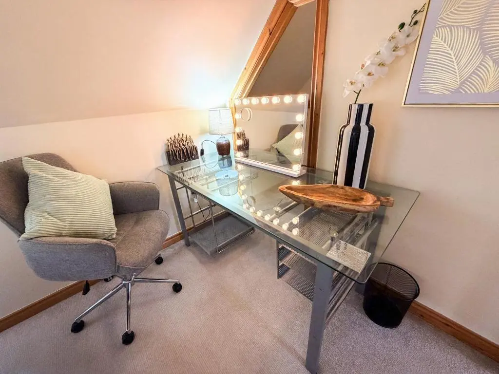 a glass desk with a chair and a mirror at Inverness Holiday House - 2 Bedroom in Inverness