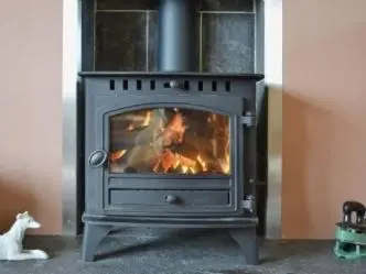 a stove with a fire in a living room at Ard Garraidh in Ardersier