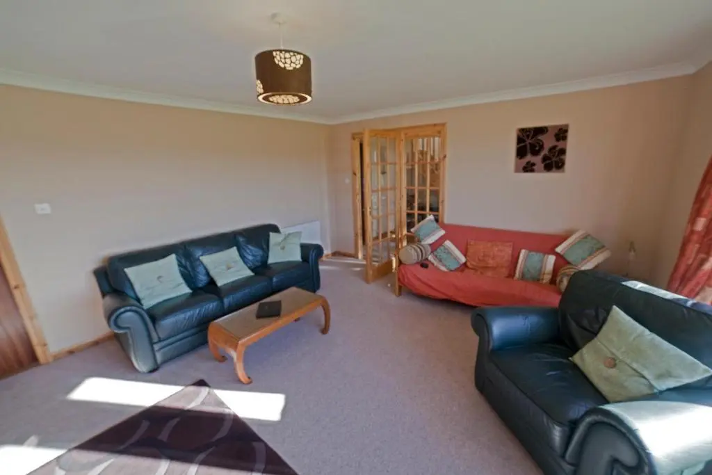 a living room with two couches and a table at Ard Garraidh in Ardersier