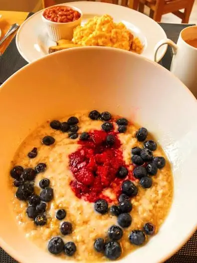 a bowl of food with blueberries and strawberries on a table at The Osprey Hotel in Kingussie