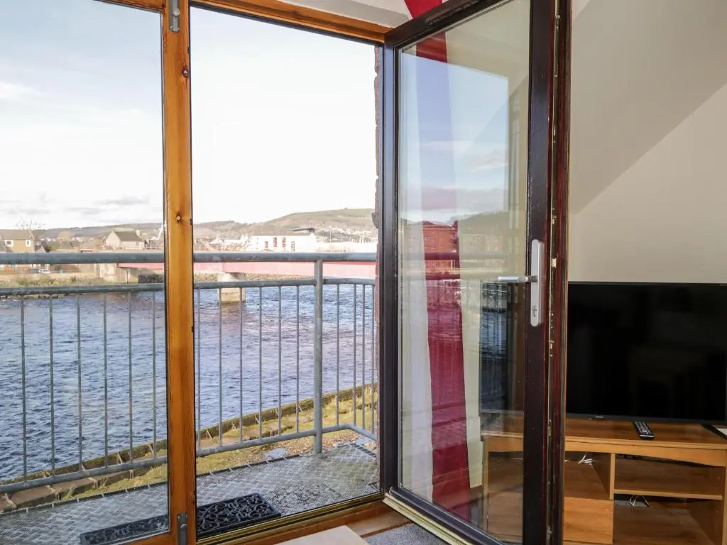 a balcony with a view of the water at Riverview Apartment in Inverness