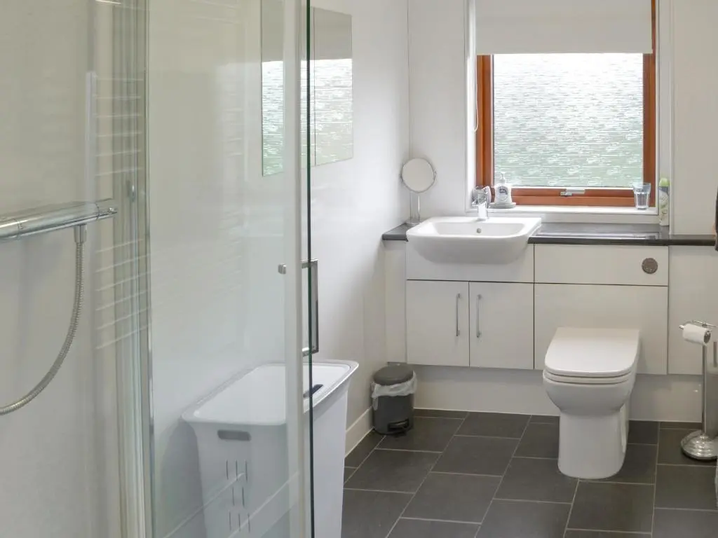 a bathroom with a toilet and a sink at Cluaran Cottage in Tain
