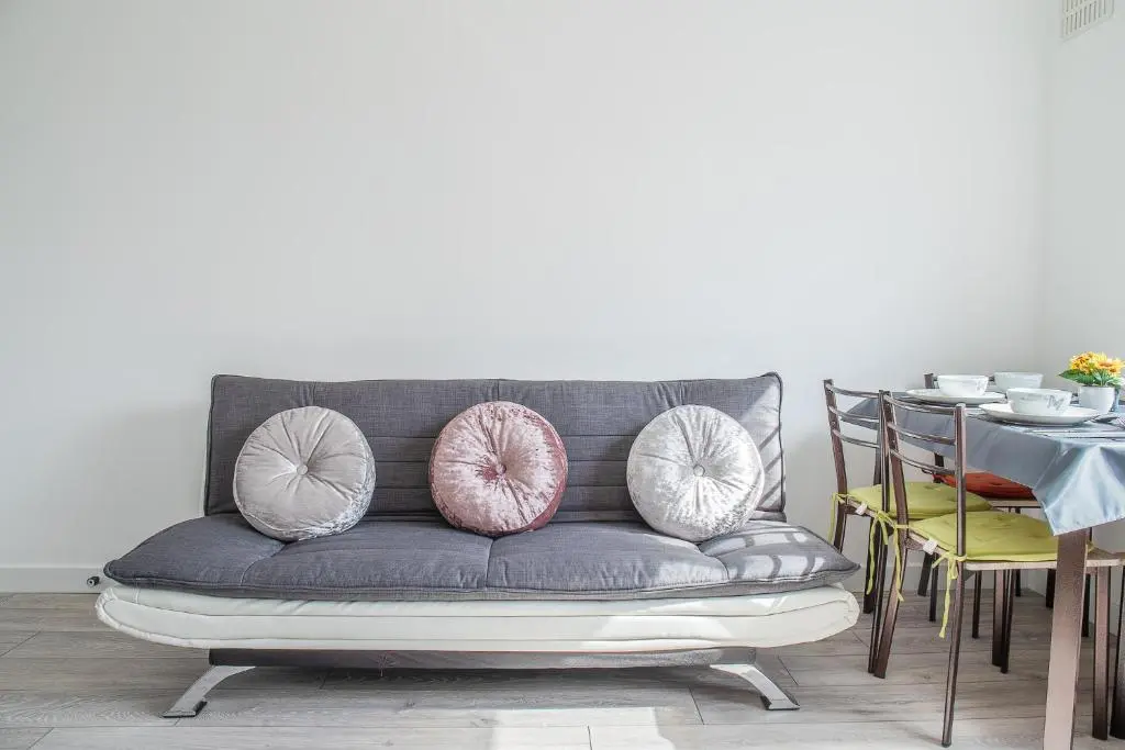 a gray couch with pink and white pillows on it at Millburn Apartment in Inverness