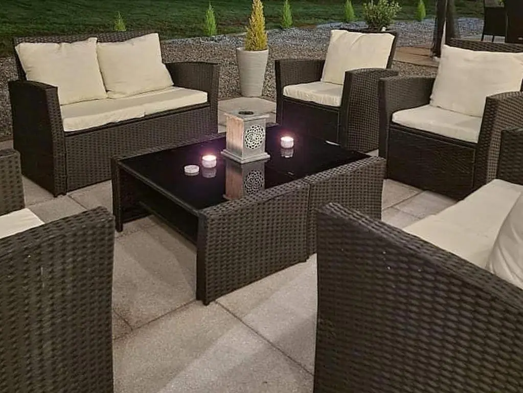 a patio with wicker chairs and a table with candles at Antfield House in Lochend