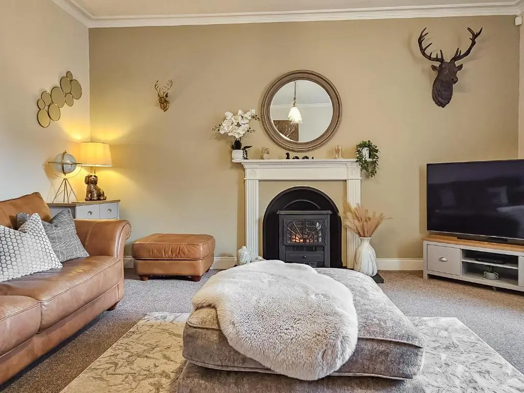a living room with a couch and a fireplace at Antfield House in Lochend
