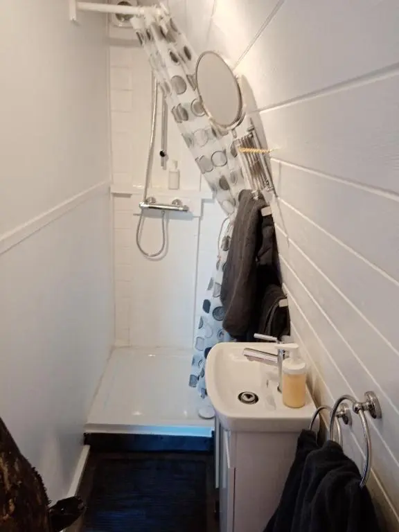 a small bathroom with a sink and a shower at Wee Hoose Glamping Pod 1 in Skail