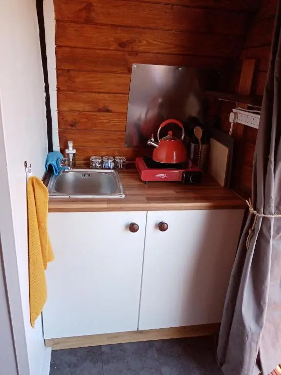 a kitchen with a sink and a tea kettle on a counter at Wee Hoose Glaping Pod 2 in Skail