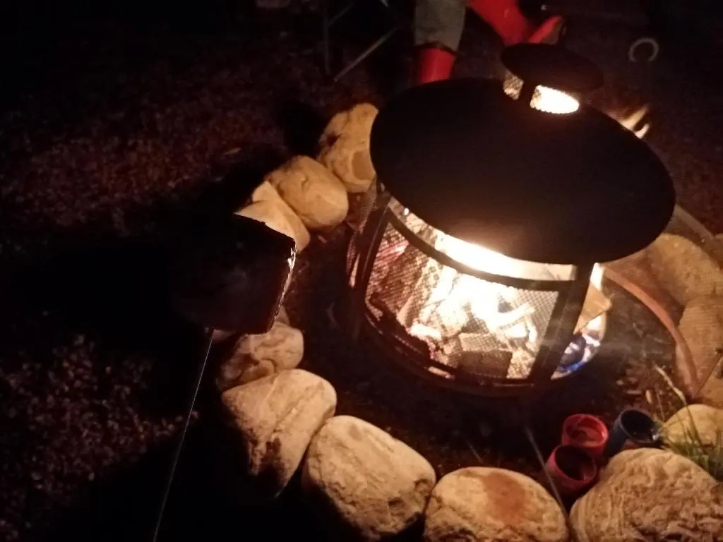 a fire pit with a lantern and some rocks at Wee Hoose Glaping Pod 2 in Skail
