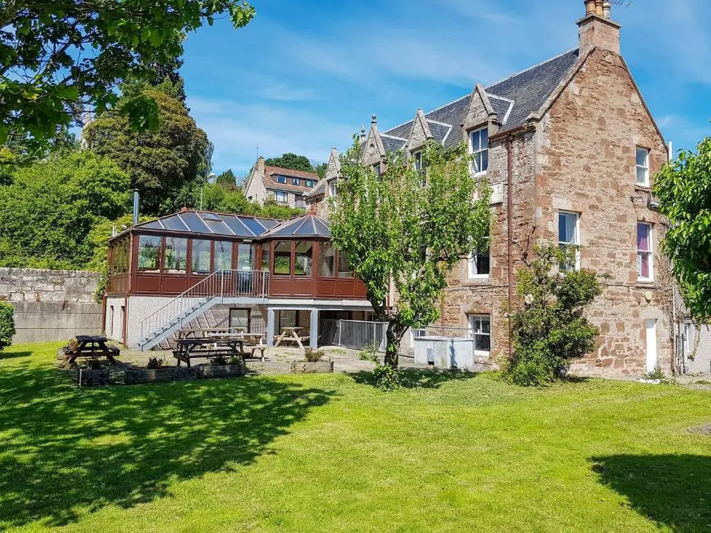 a large brick building with a table in a yard at The Red Kite - Uk31003 in Avoch