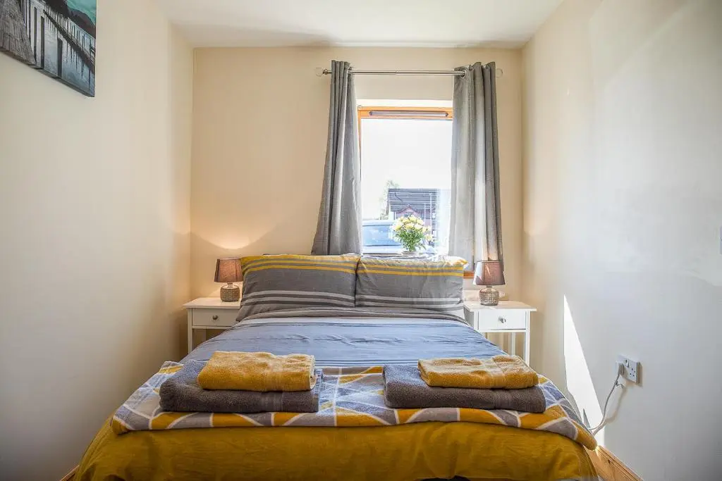 a bedroom with a bed with towels on it at Caledonian 2 bedroom free parking in Inverness