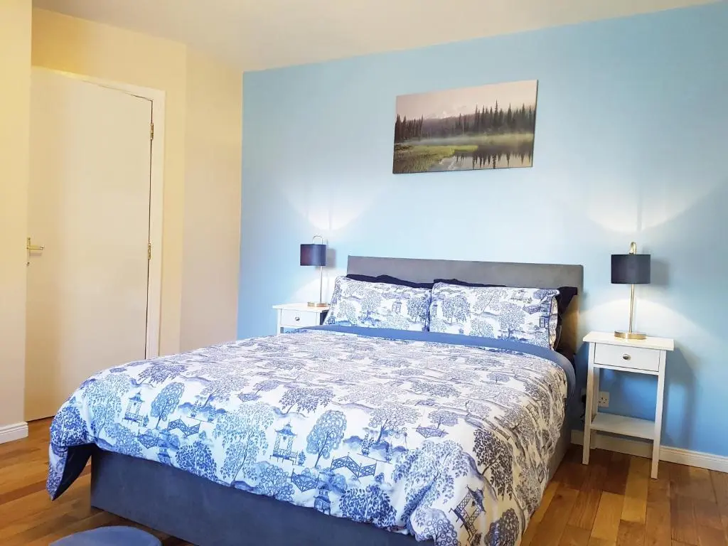 a bedroom with a bed with a blue comforter at Inverness City 2 bedroom free parking in Inverness