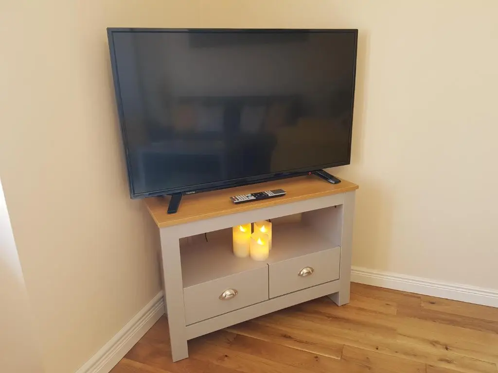a flat screen tv on a tv stand in a room at Inverness City 2 bedroom free parking in Inverness