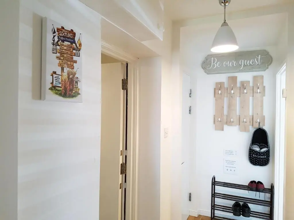 a hallway with a door with a sign on the wall at Inverness City 2 bedroom free parking in Inverness