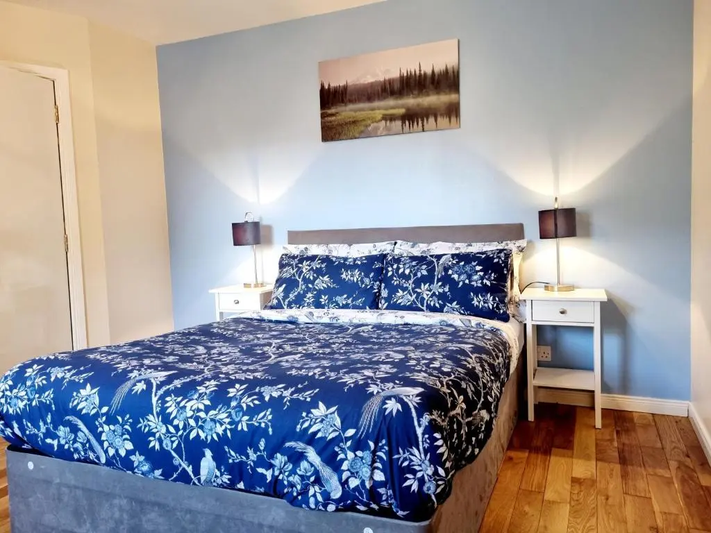 a blue bedroom with a bed and two night stands at Inverness City 2 bedroom free parking in Inverness