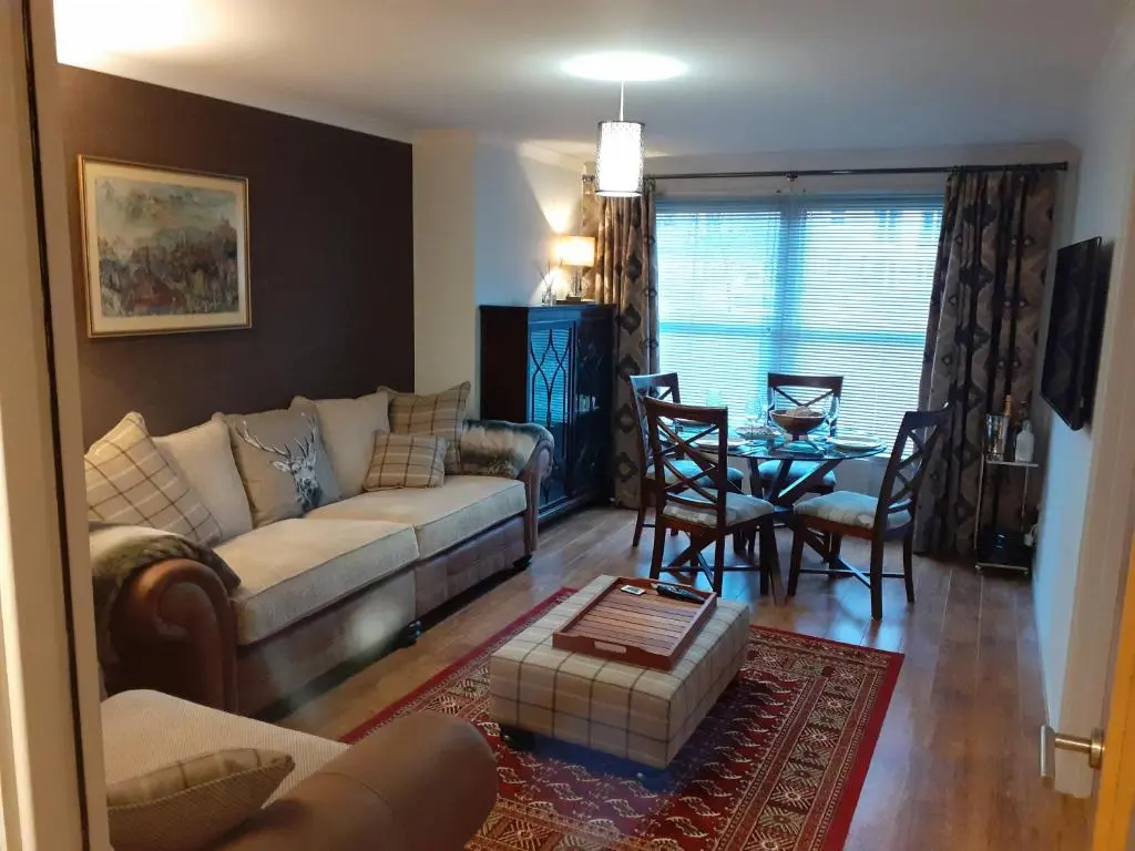 a living room with a couch and a table at Bishops Park Apartment in Inverness
