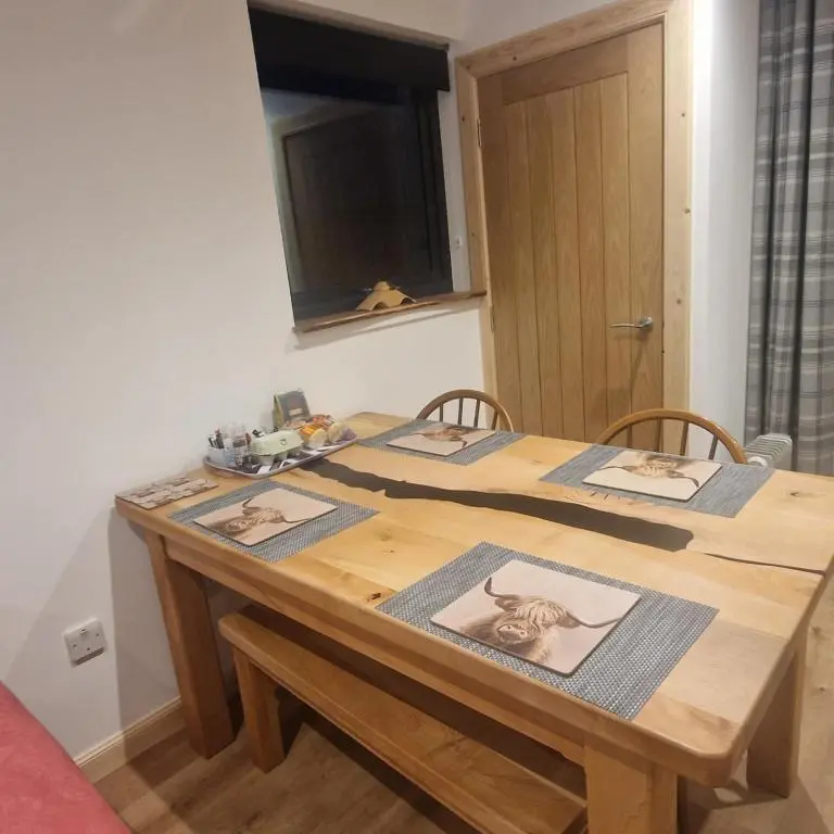 a wooden table with three pictures on it at Pleasant Point Holiday Cottages in Rosemarkie