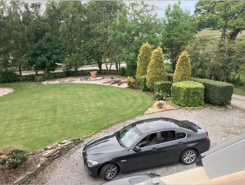 a car parked on the side of a driveway at Kilberry Guest House in Beauly