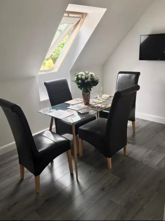a dining room table with chairs and a vase of flowers at Kilberry Guest House in Beauly