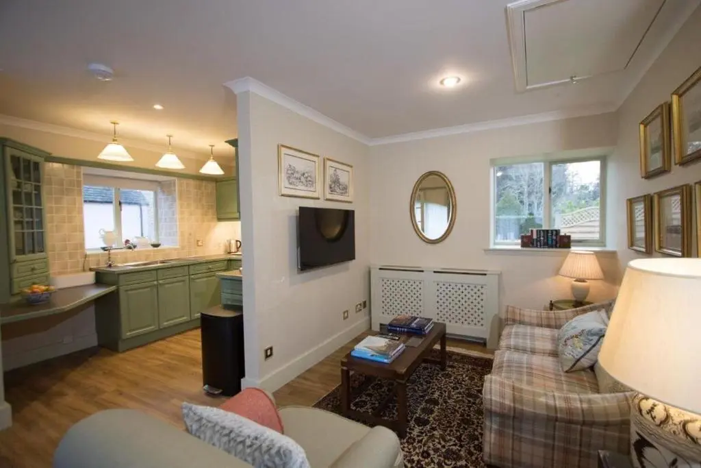 a living room with a couch and a table at Balnagown Estates Peat Cottage in Kildary