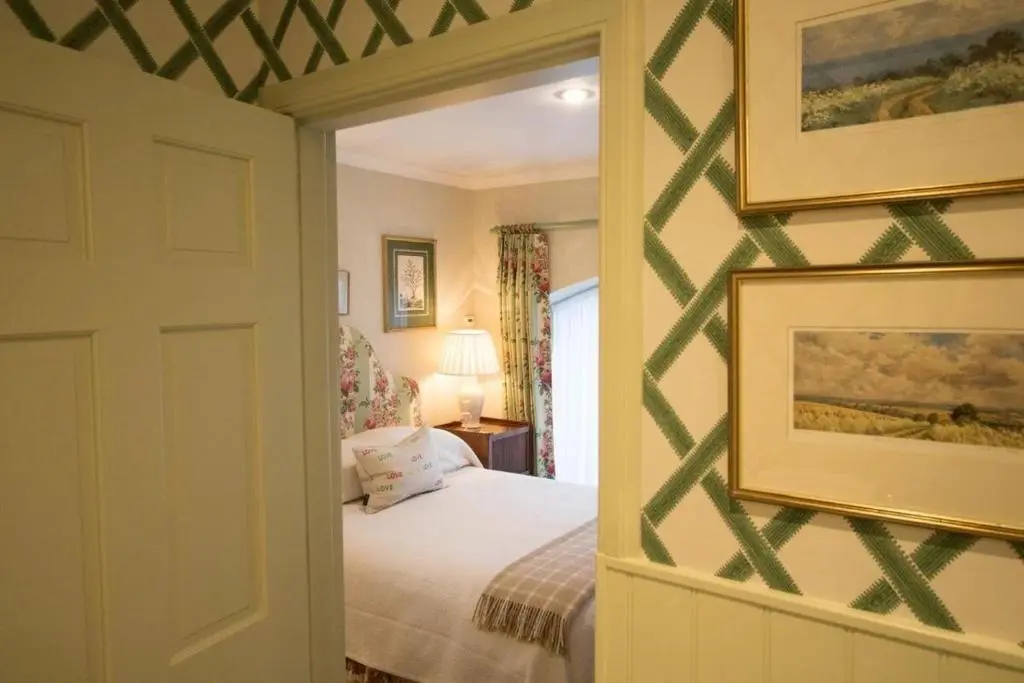a bedroom with a bed and a painting on the wall at Balnagown Estates Peat Cottage in Kildary