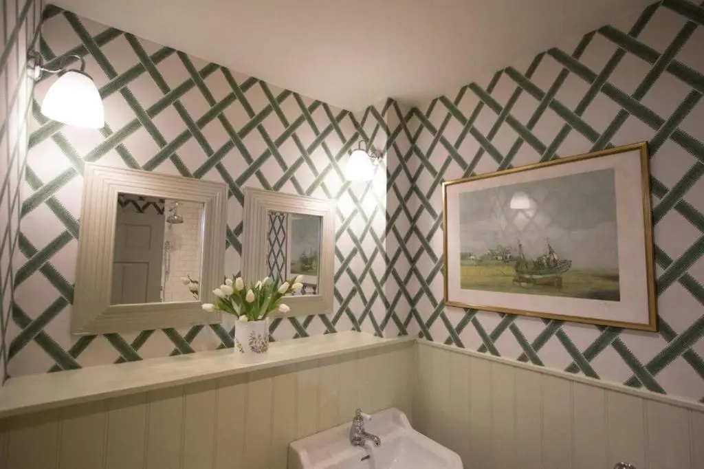a bathroom with a checkered wallpaper and a sink at Balnagown Estates Peat Cottage in Kildary