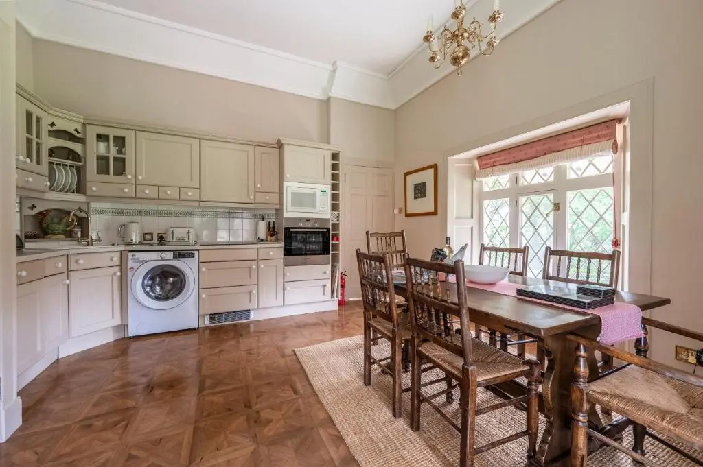 a kitchen with a table and chairs and a dining room at Balnagown Estates Swiss Cottage in Barbaraville