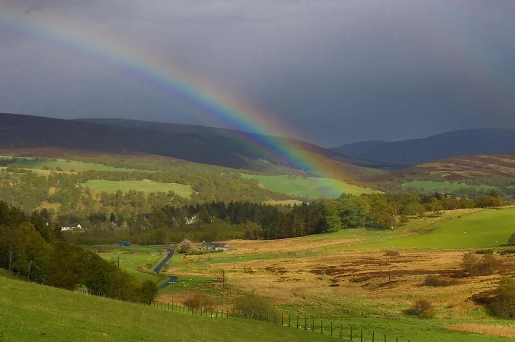 a rainbow in the middle of a field at Easter Corrie Cottages in Ballindalloch